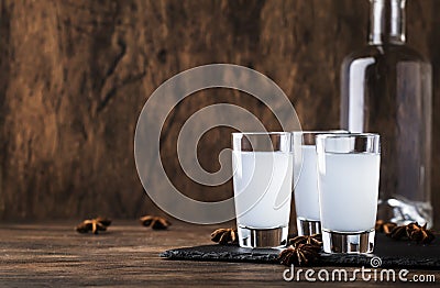 Ouzo - Greek anise brandy, traditional strong alcoholic drink in glasses on the old wooden table, place for text Stock Photo