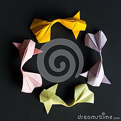 Circular round figure of handmade paper craft origami gold koi carp fishes on black background.Pattern size 1*1, view top Stock Photo