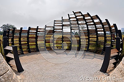 An oval shaped bird hide made of curved dark brown black wooden planks at Singapore Lakeside Gardens Editorial Stock Photo