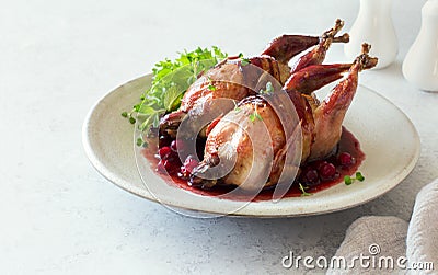 Oven baked quails served with berry sauce on stone plate close up Stock Photo