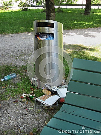 Over full trash can in city park Stock Photo
