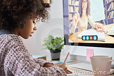 Over shoulder view of black pupil sitting learning online at home with tutor. Stock Photo
