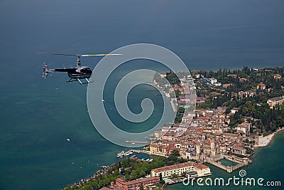 Blue helicopter over a small Italian island in the Mediterranean sea. Stock Photo