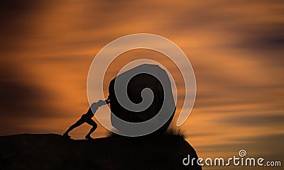 Overcame Obstacles, Sisyphus and Hard Work Concept. Young man Pushing Big Rock Forward At sunset. Stock Photo