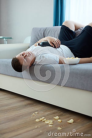 Overeat fat boy sleep on sofa in living room Stock Photo