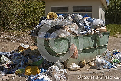 Overfilled dumpster in ghetto in the street, trash recycling Stock Photo