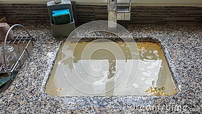 Overflowing kitchen sink, clogged drain. Stock Photo