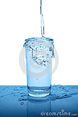 Overflowing mineral water in transparent glass with drops and bu Stock Photo