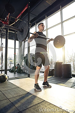 The male athlete training hard in the gym. Fitness and healthy life concept. Stock Photo