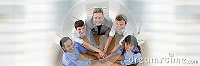 Overhead of business team looking up and putting hands together at table and blurry white transition Stock Photo