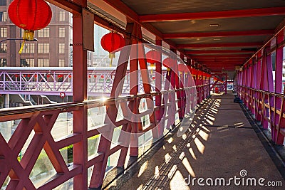 Overhead pedestrian walking bridge with traditional chinese red lamps leads to nearby facilities Editorial Stock Photo
