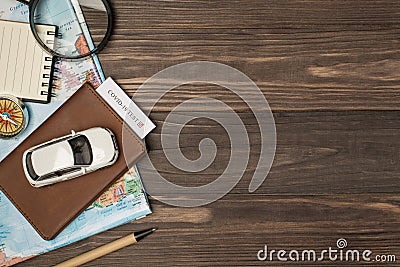Overhead photo of brown passport with covid-19 test inside car map magnifier compass notepad and pen isolated on the wooden Stock Photo