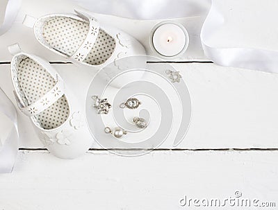 Overhead photo of pair of white baby booties, candle, ribbon and Stock Photo