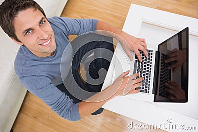 Overhead portrait of a man using laptop in living room Stock Photo