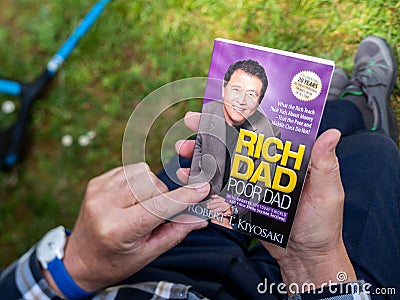 Overhead POV view of senior male hand hodling in had reading the iconic book Editorial Stock Photo