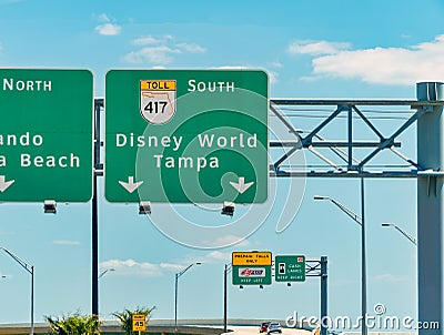 Overhead road direction signs showing way to Disney World Editorial Stock Photo