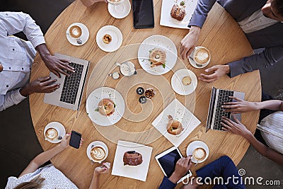 Overhead Shot Of Businesspeople Meeting In Coffee Shop Stock Photo