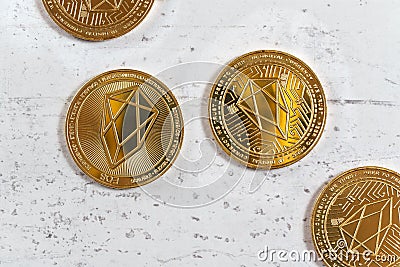 Overhead shot, golden commemorative EOS - EOSIO cryptocurrency - coins on white stone board Stock Photo