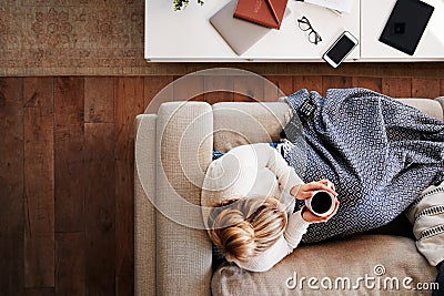 Overhead Shot Looking Down On Woman At Home Lying On Sofa Watching Television Stock Photo