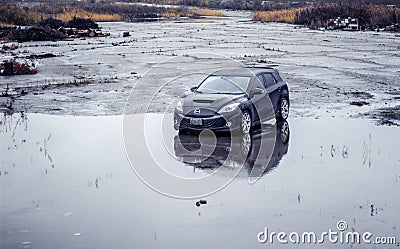 A Black 2010 Mazdaspeed3 n an abandoned wet parking lot Editorial Stock Photo