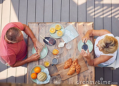 Overhead Shot Of Retired Couple Outdoors On Deck At Home Eating Breakfast Stock Photo