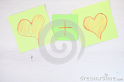 Overhead shot of two illustrated hearts and a plus sign in between on white background Stock Photo