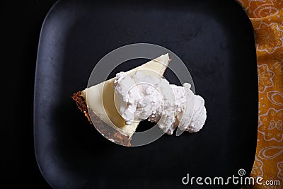 Overhead shot of white sauce over a piece of cheesecake Stock Photo
