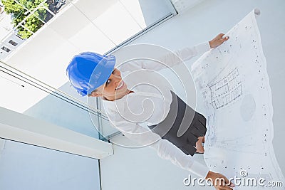 Overhead of a smiling architect holding a blueprint Stock Photo