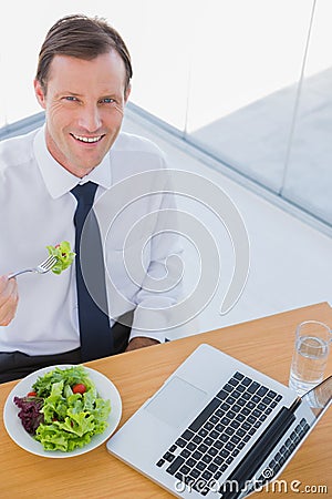 Overhead of a smiling businessman eating a salad Stock Photo