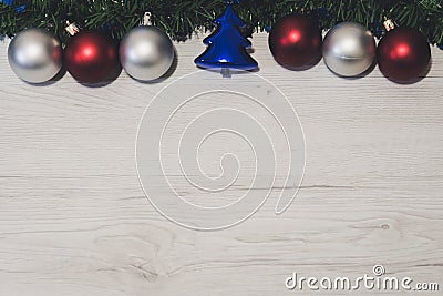 Overhead top view of colorful Christmas ornaments hanging on a fir branch on a wooden background Stock Photo