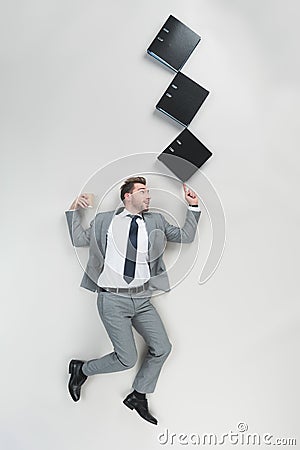 overhead view of businessman with coffee to go holding stack of folders on one finger Stock Photo