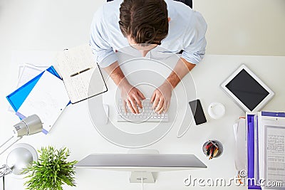 Overhead View Of Businessman Working At Computer In Office Stock Photo