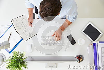 Overhead View Of Businessman Working At Computer In Office Stock Photo