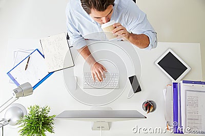 Overhead View Of Businessman Working At Computer In Office Stock Photo