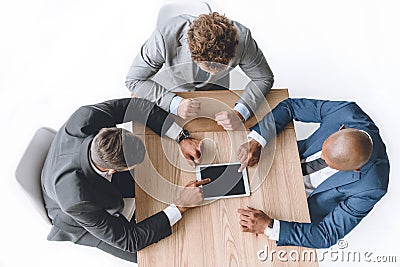 Overhead view businessmen using tablet during meeting Stock Photo