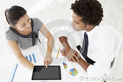 Overhead View Of Businesswoman And Businessman Working At Desk Together Using Digital Tablet Stock Photo