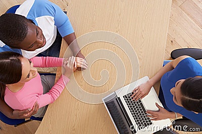Overhead View Of Couple Talking To Financial Advisor Stock Photo