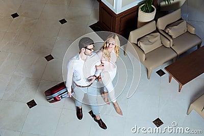 overhead view of happy couple of travelers walking with luggage Stock Photo