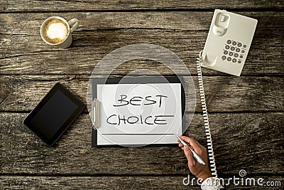 Overhead view of male hand writing Best choice on white sheet of Stock Photo