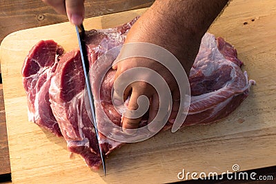 Overhead view of raw piece of pork on wooden background. Piece of fresh boneless pork, neck part or collar. Big piece of red raw m Stock Photo