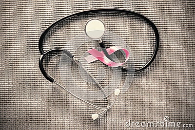 Overhead view of stethoscope by pink Breast Cancer Awareness ribbon Stock Photo