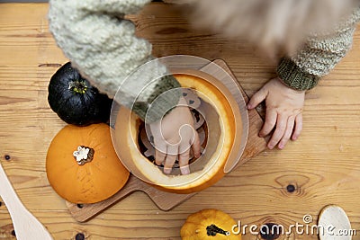 Overhead view of a toddlers hands playing with a pumpkin whilst making a lantern decoration for halloween Stock Photo