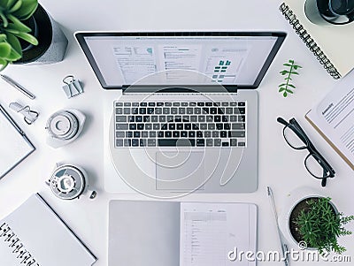 An overhead view of a virtual desk with an open laptop displaying an easytouse document editor surrounded by simple clean Stock Photo
