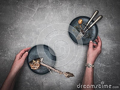 Woman`s hands tidying up skeleton sea breams - dorado sea fish on plate.e. Stock Photo