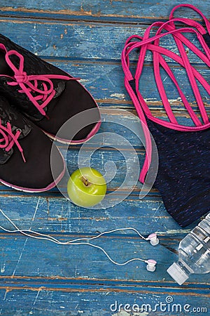 Overhead view of womenswear with Granny Smith apple and bottle by headphones Stock Photo