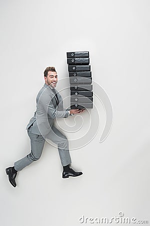 overhead view of young businessman carrying stack of folders Stock Photo