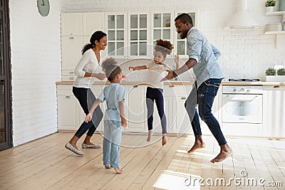 Overjoyed african american couple jumping with joyful energetic children. Stock Photo