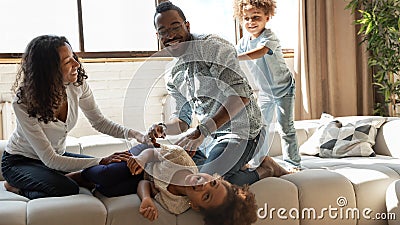 Overjoyed african american family involved in funny domestic activity. Stock Photo