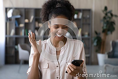 Overjoyed african mixed woman celebrating online success. Stock Photo