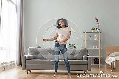 Overjoyed black woman have fun dancing at home Stock Photo